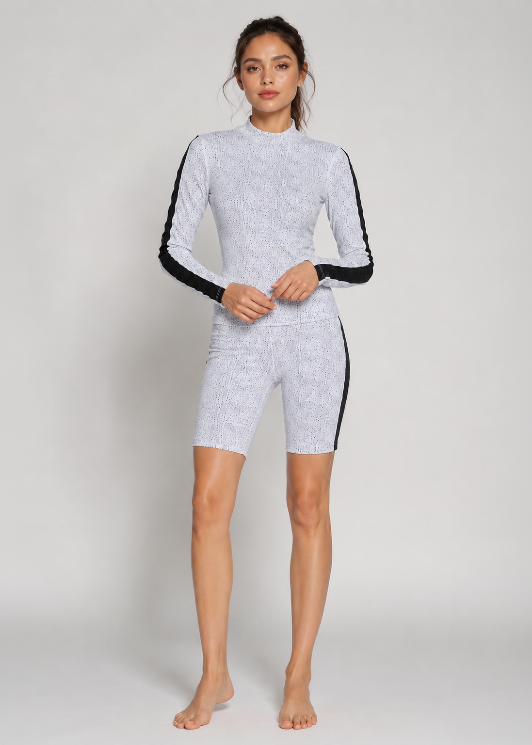 Woman wearing a gray and black bodysuit on a white background