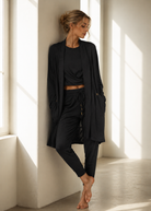 Woman in black outfit standing in a sunlit room